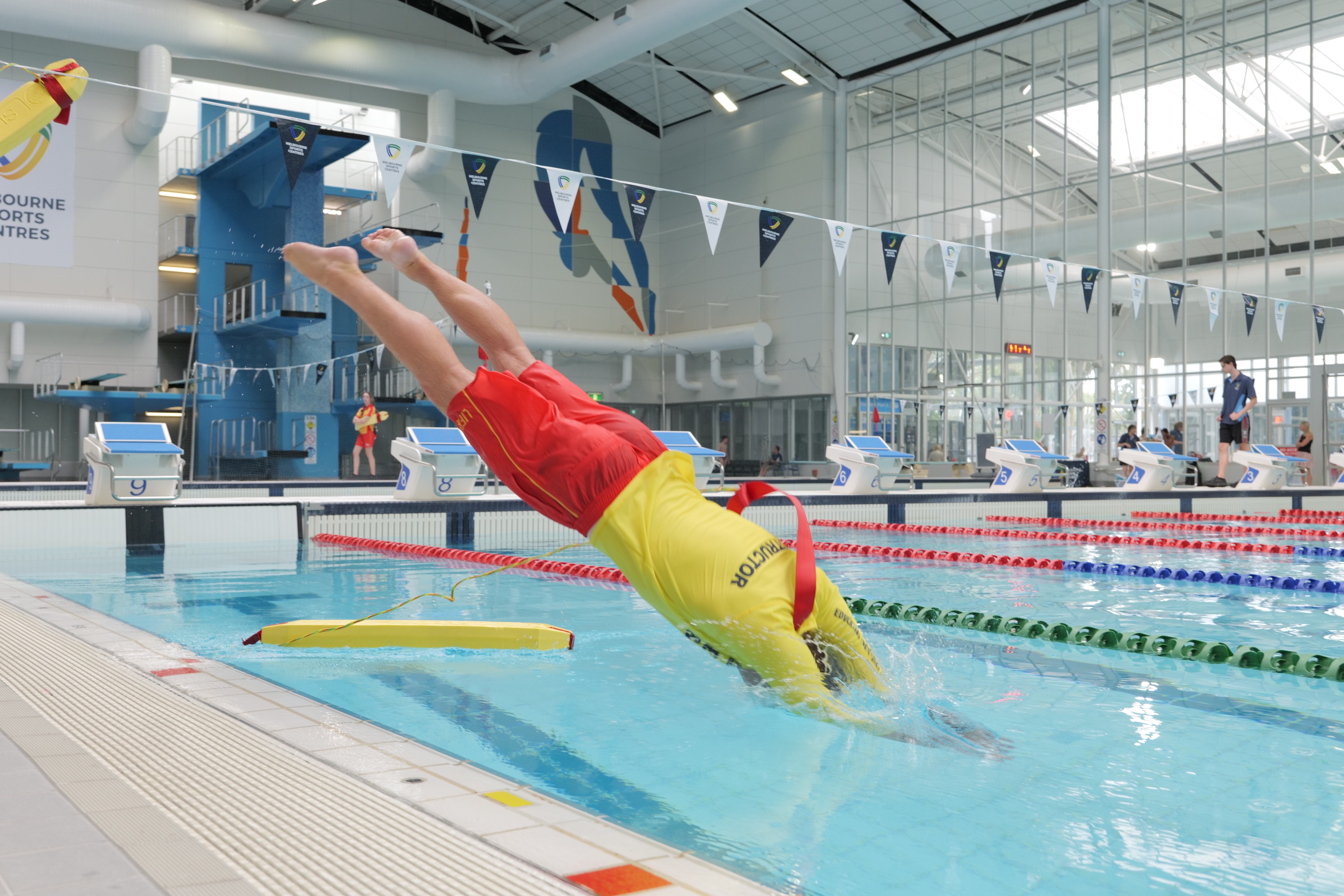 Pool lifeguard diving into pool