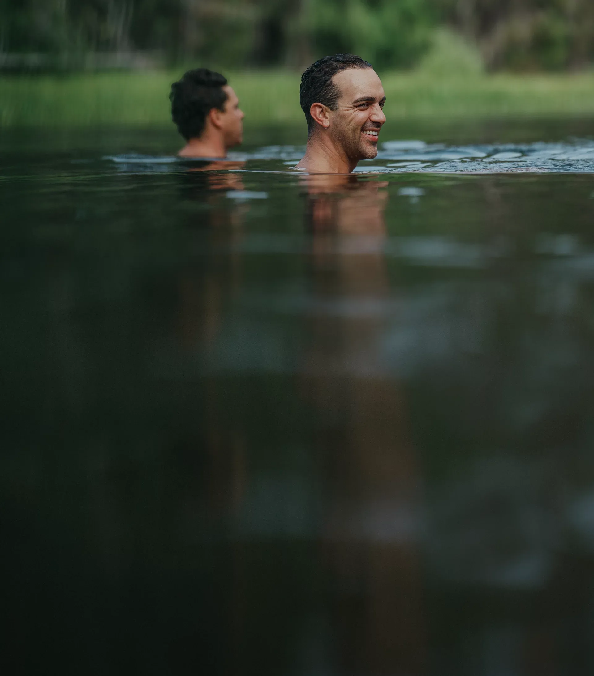 Two people swim together in a river